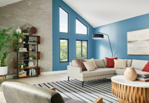 large living room with a blue wall filled with windows that fit the wall in different shapes